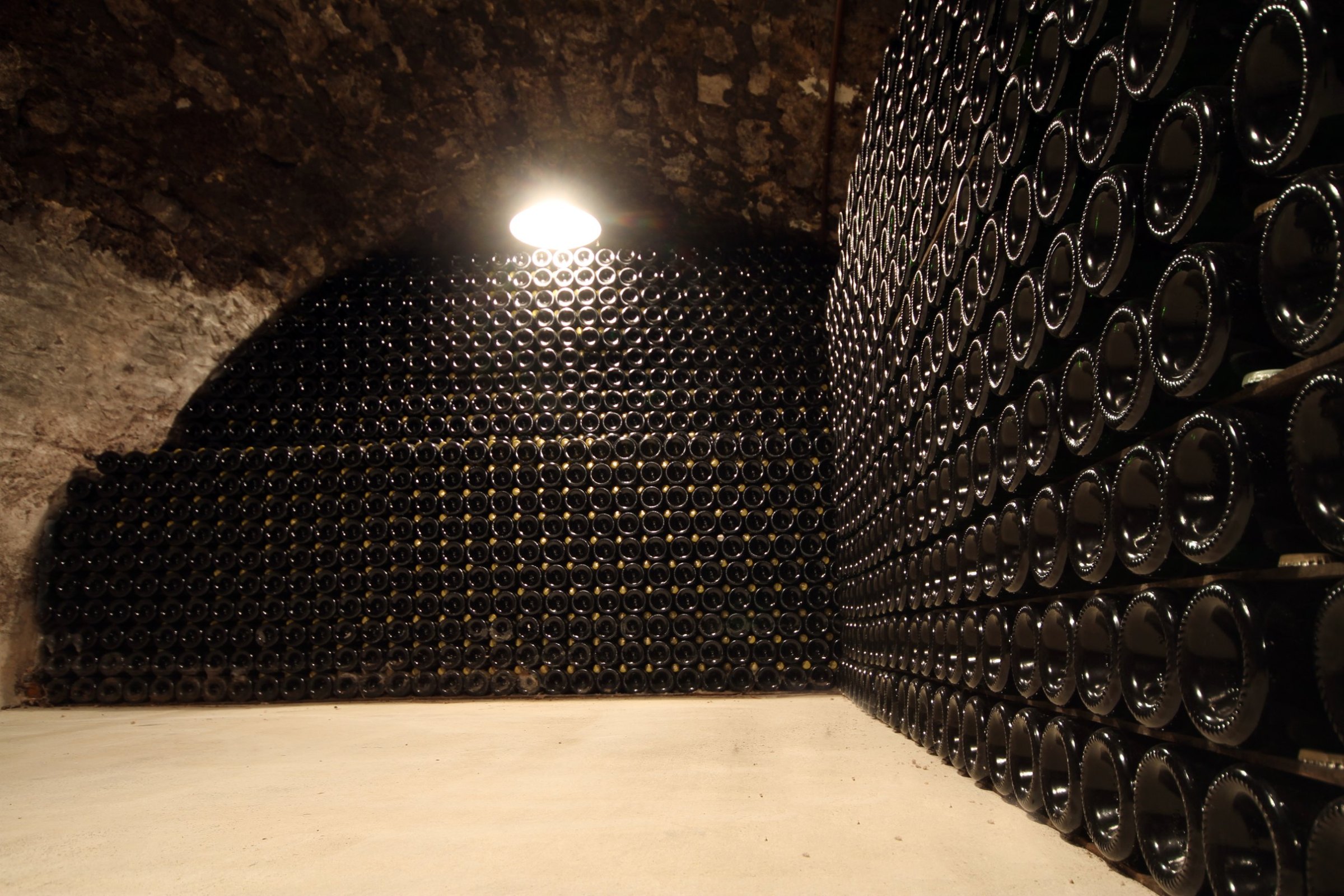 Bouteilles sur lattes dans une cave voûtée creusée dans la craie